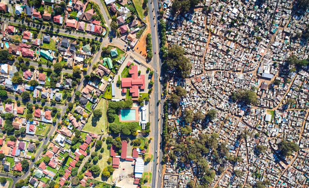 Aerial view showing stark contrast between wealthy neighborhood and dense informal settlement
